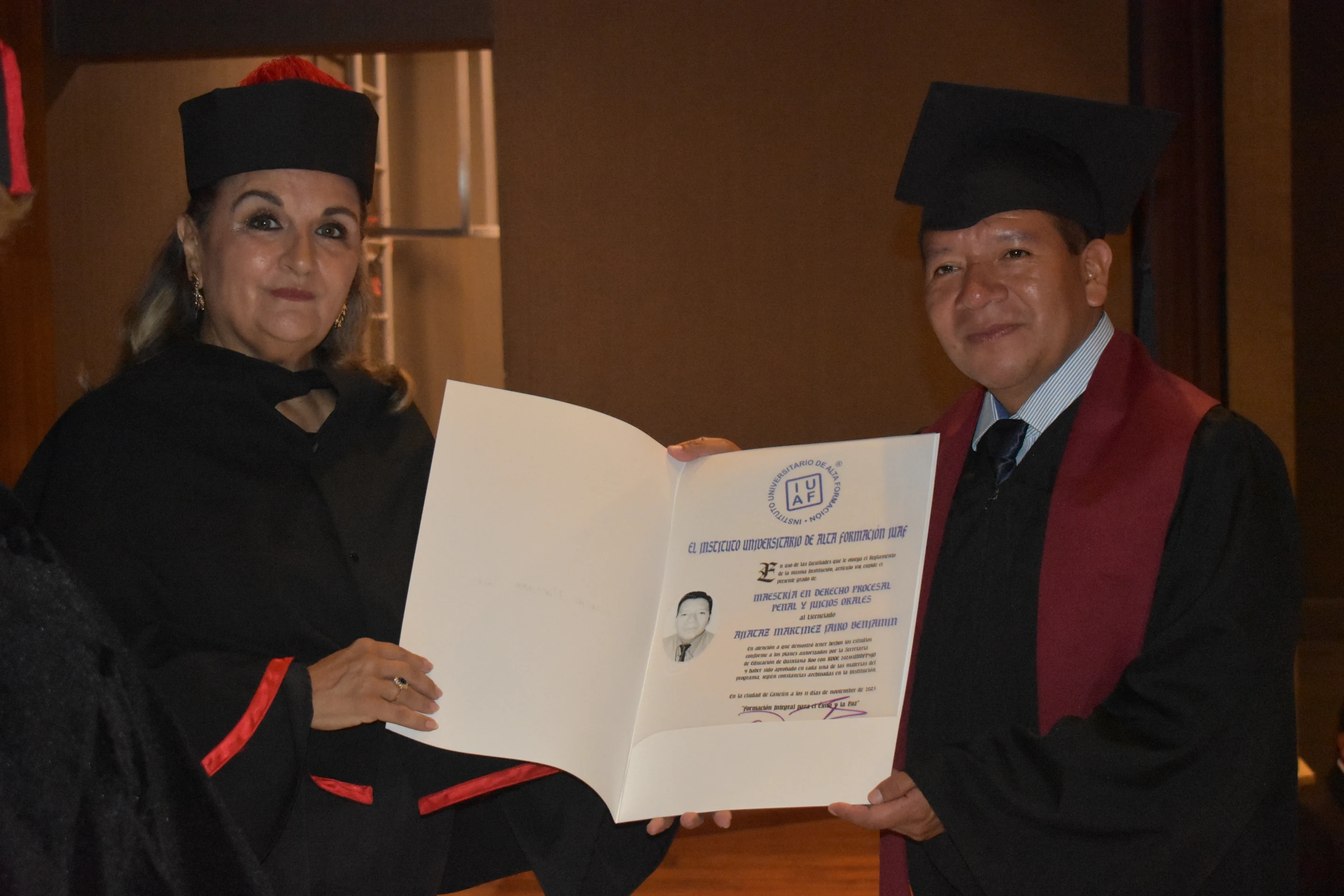Una académica entrega su diploma de maestría a un egresado IUAF