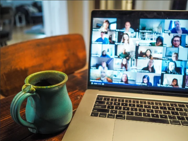 Computadora con una videollamada grupal sobre una mesa de estudio