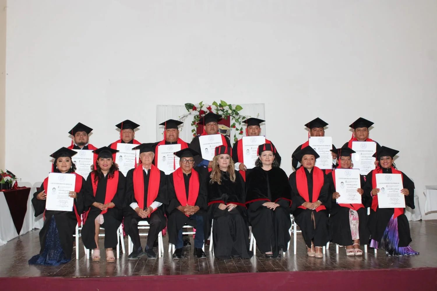 Graduados IUAF sostienen sus diplomas durante una ceremonia